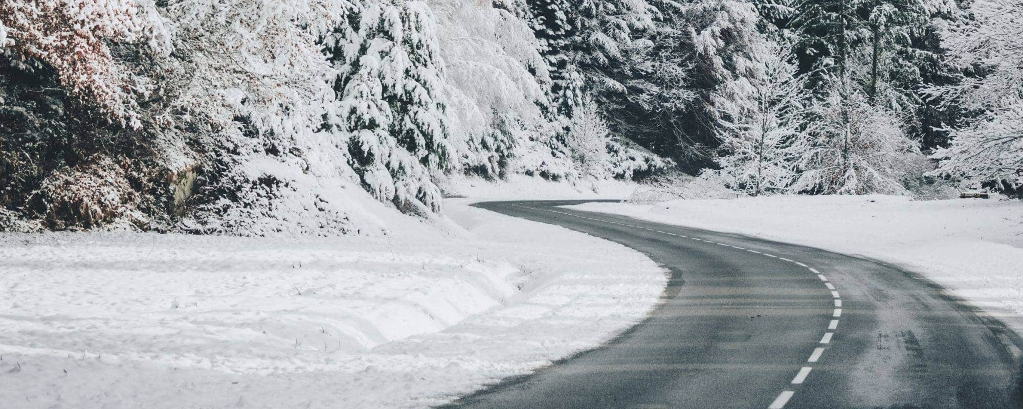 Cleared road winding through snowy scenery