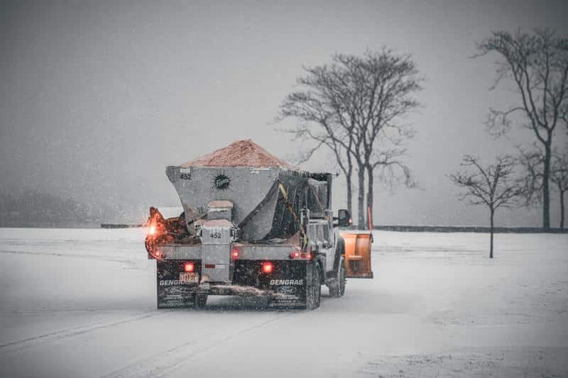 Gritting vehicle spreading de-icing salt on a snowy road